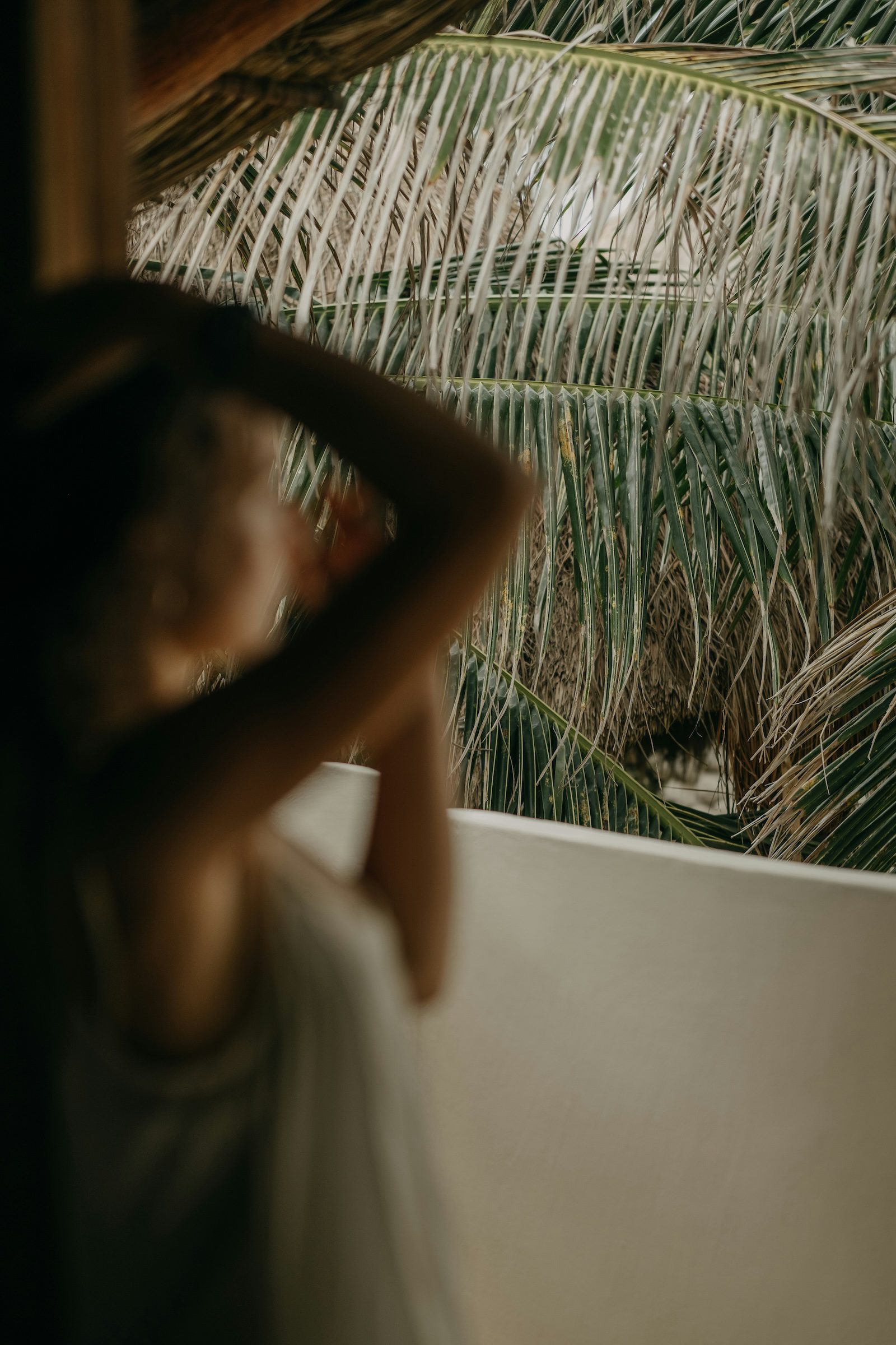 Natalie looking outside into jungle leaves