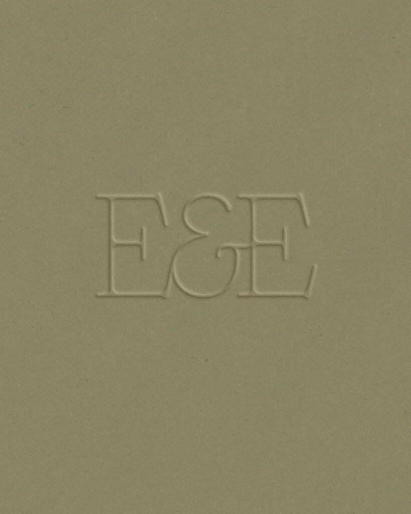 Embossed Earth & Ember monogram on green paper