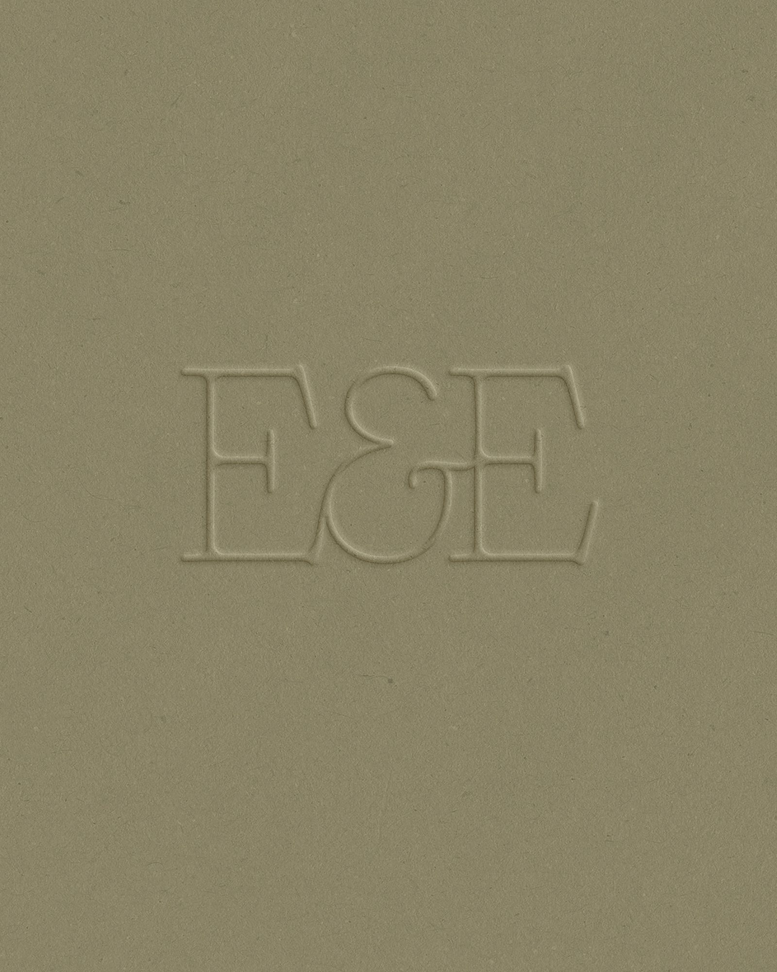 Embossed Earth & Ember monogram on green paper
